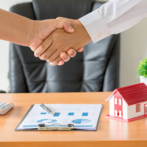 hands of agent and client shaking hands after signed contract bu